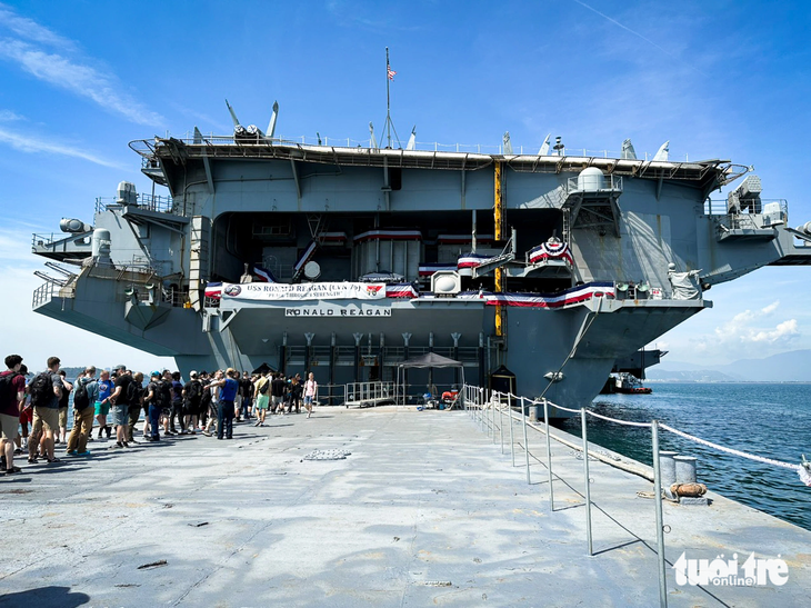 Đoàn khách tham quan chuẩn bị cập mạn tàu sân bay để đi lên bằng cửa đuôi - Ảnh: T.L.