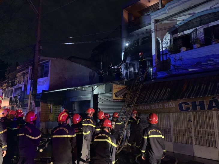 Cháy lớn nhà 2 tầng quận 10, TP.HCM nửa khuya, cứu 5 người mắc kẹt ra ngoài- Ảnh 1. Lực lượng cảnh sát PCCC có mặt, đưa cầu thang lên tầng 1 để cứu người mắc kẹt - Ảnh: MINH KHIÊM