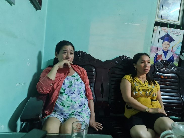 Chìm tàu câu mực 13 ngư dân mất tích: Đêm trắng âu lo - Ảnh 1. Chị Phạm Thị Liên (trái) khóc nghẹn khi hay tin chồng mất tích, chị Liên đang mang bầu gần 7 tháng - Ảnh: TRẦN MAI