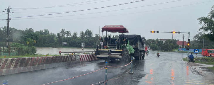 Các phương tiện rải thảm nhựa trên quốc lộ 1A trong lúc trời đang mưa được người dân ghi lại - Ảnh: DUY MẠNH Đơn vị thi công cho thảm nhựa trên quốc lộ 1 qua thị trấn Phù Mỹ trong lúc trời đang mưa - Ảnh: DUY MẠNH