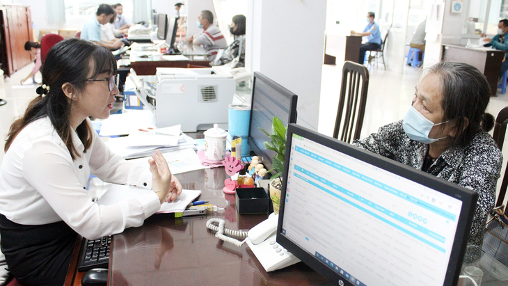 Chọn phục vụ sự hài lòng, hạnh phúc của dân - Ảnh 1. Cán bộ trẻ tiếp và giải đáp các thắc mắc về thủ tục, hồ sơ quyết toán bảo hiểm cho bà con - Ảnh: Q.L.
